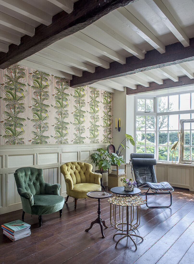 Vintage living room with patterned wallpaper and various armchairs