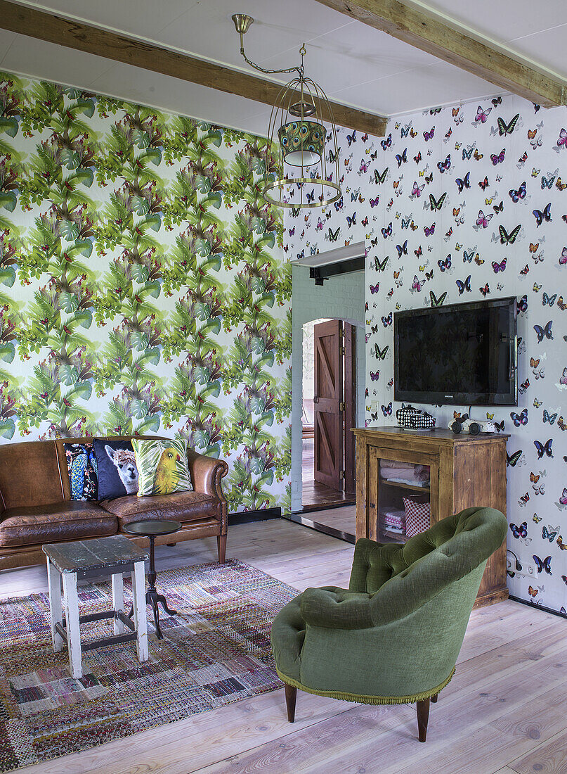 Living room with butterfly wallpaper, leather sofa and green armchair