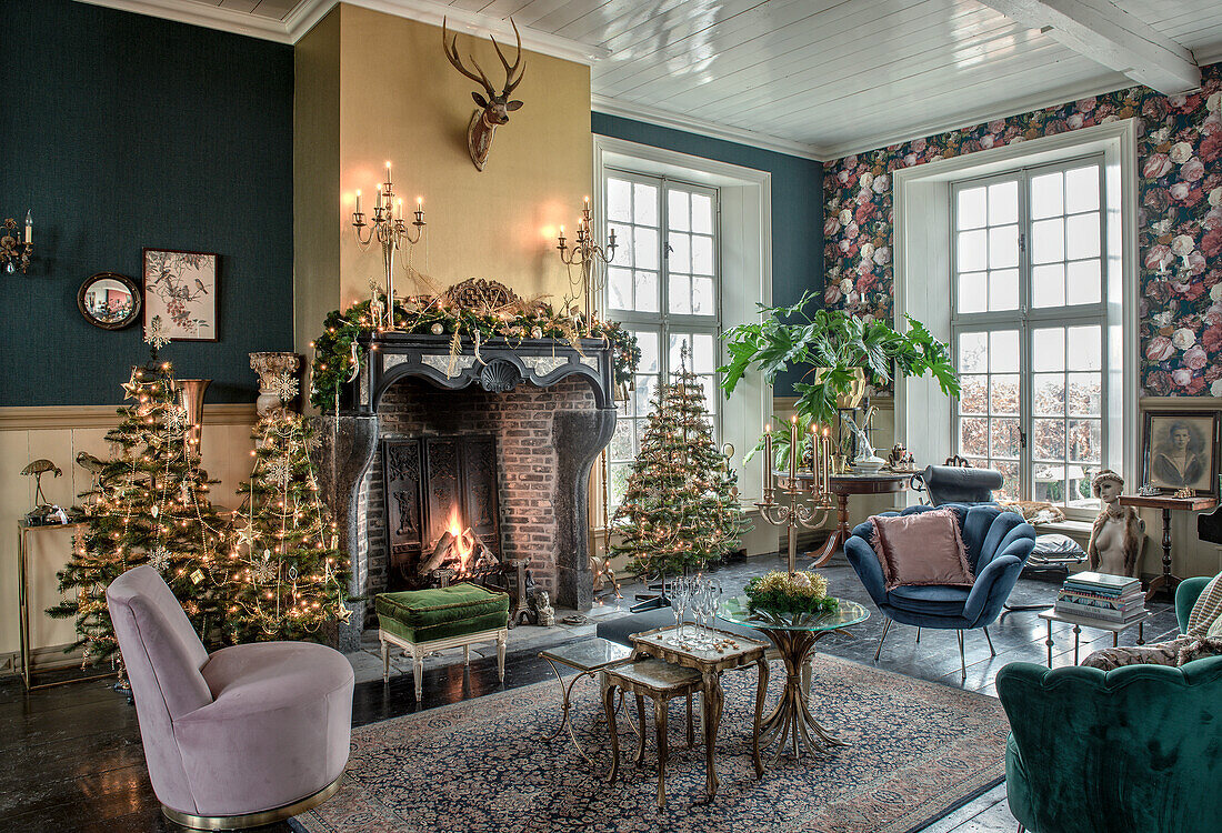 Wohnzimmer mit weihnachtlich geschmücktem Kamin, Vintage-Möbeln und großen Fenstern