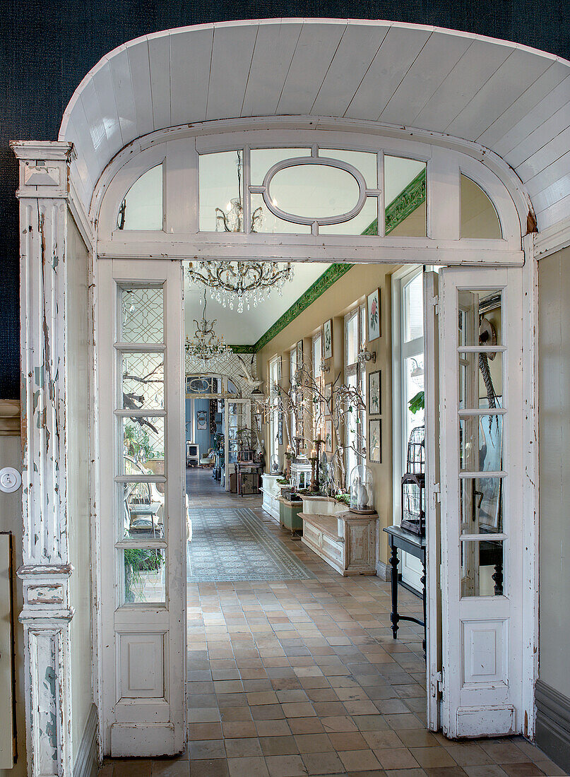 Archway with double doors, tiled floor and chandeliers