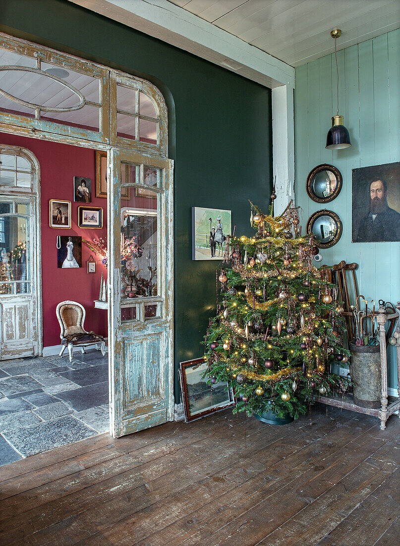 Hallway decorated for Christmas with Christmas tree and antique furniture