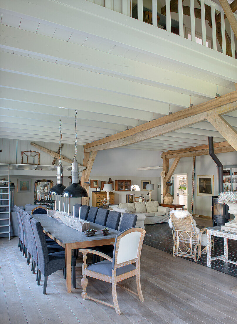 Open-plan living and dining area with wooden beams and black pendant lights