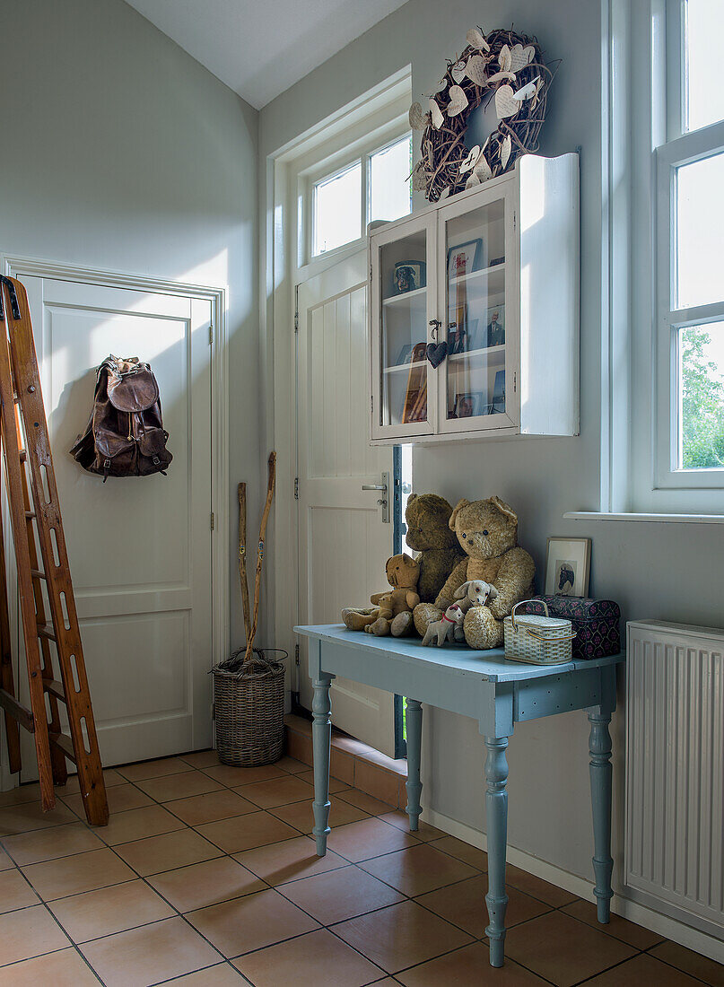 Entrance area with pastel blue table, soft toys and wall shelf