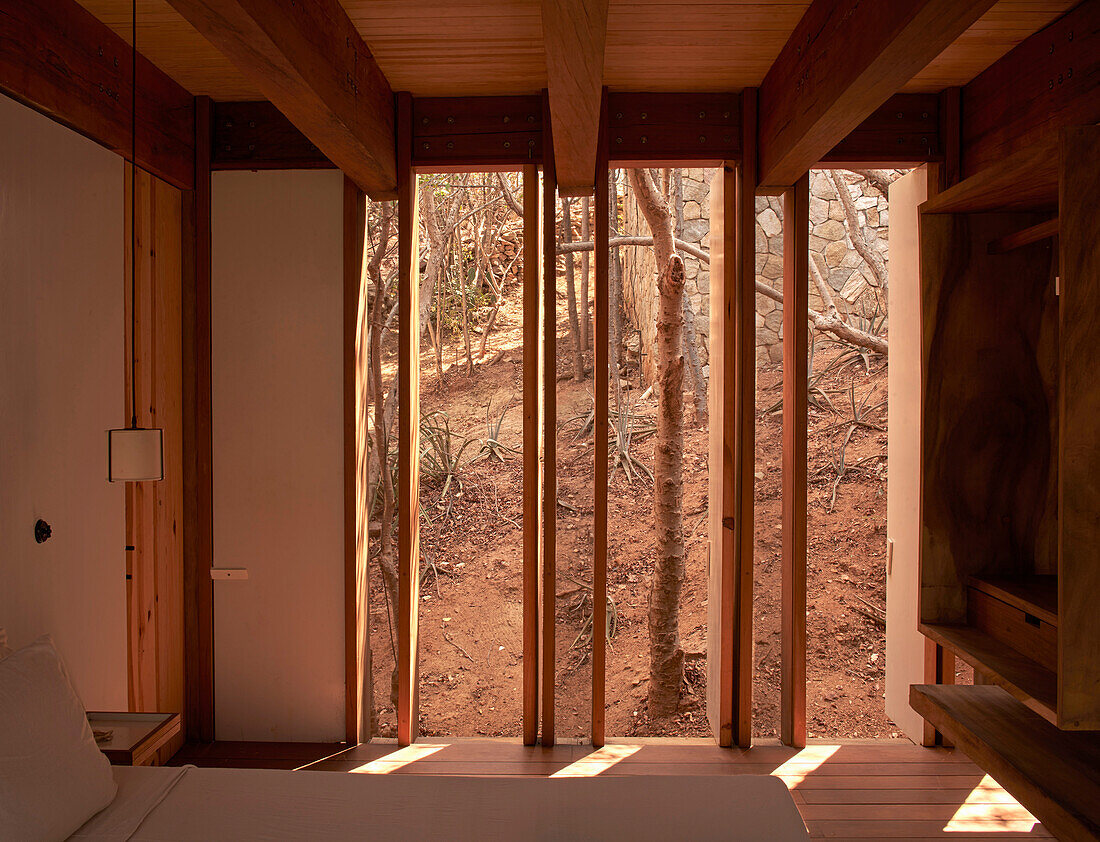 Bedroom with wooden beamed ceiling and view of nature