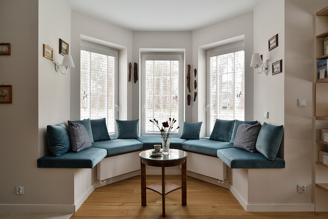 Corner window bench with blue upholstery in bay window