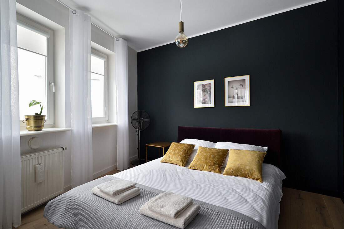 Modern bedroom design with dark walls and gold-colored accents