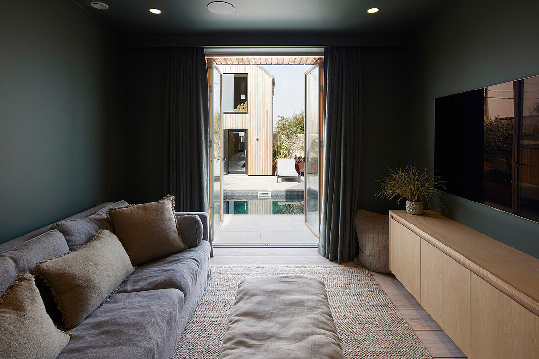Room with large TV, view of the patio and pool