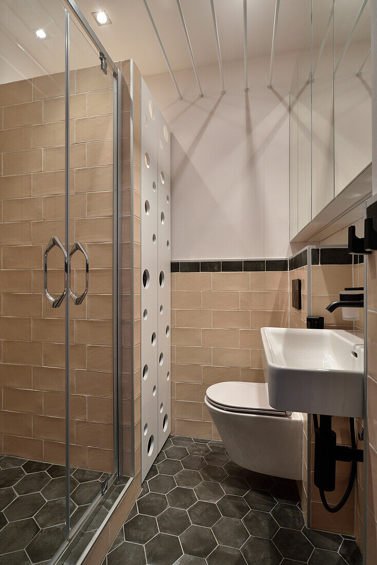 Modern gestaltetes Badezimmer mit Duschkabine und Wandfliesen in Beigetönen