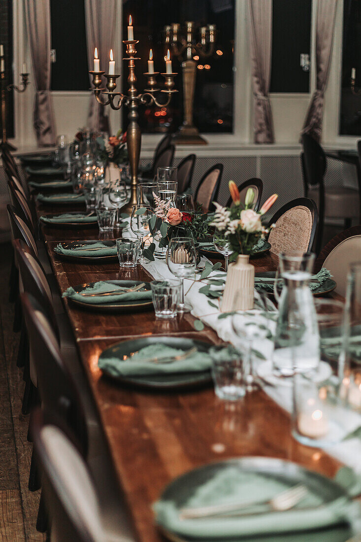 Festively set dining table with candlesticks and floral decorations