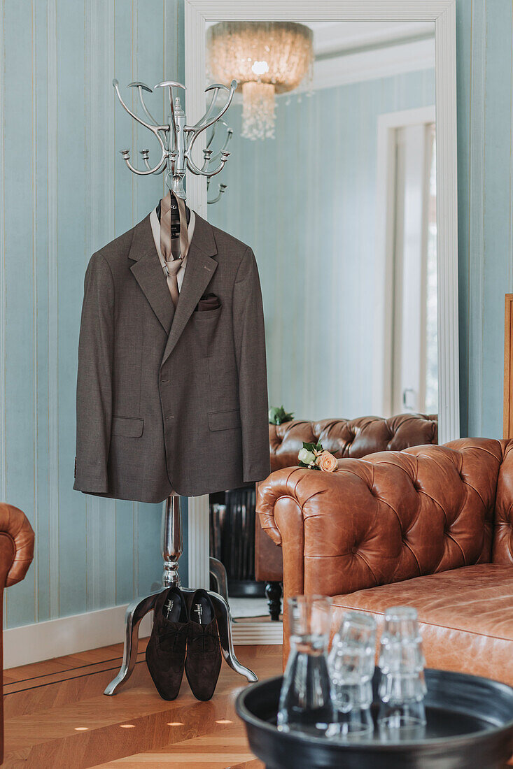 Men's suit on a coat rack in the living room