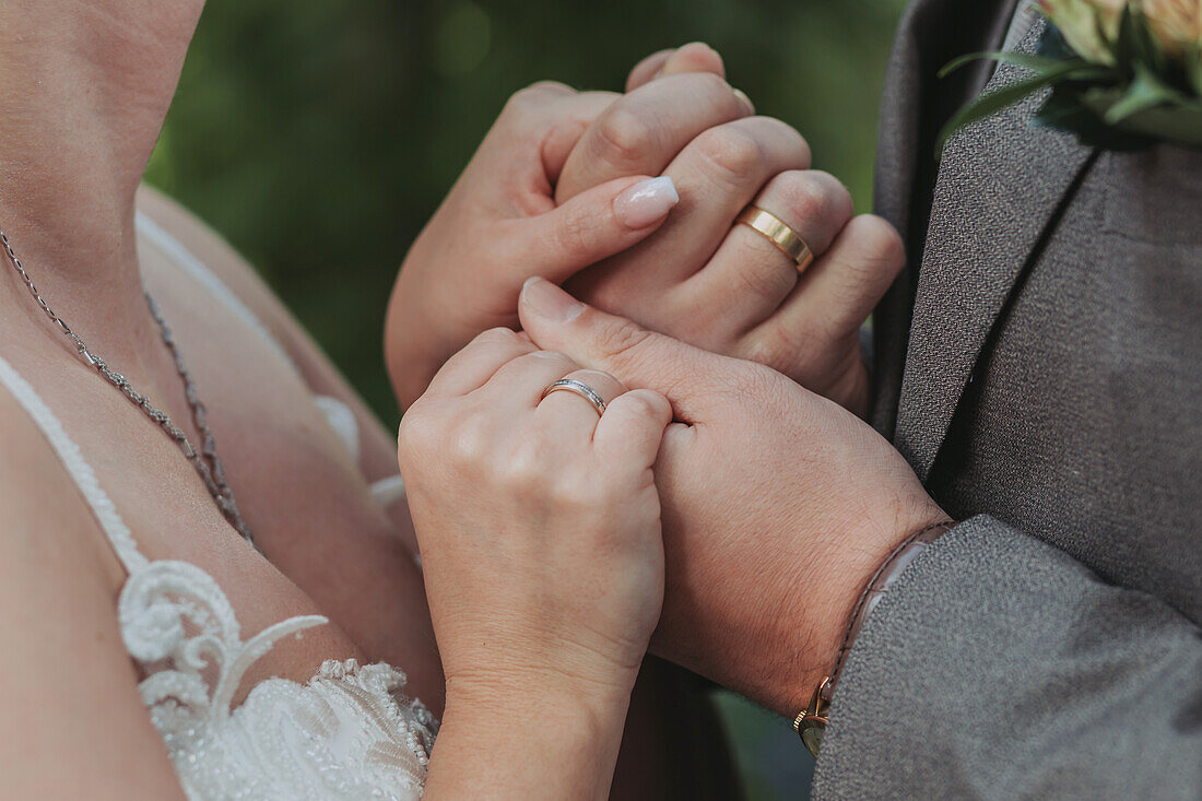 Bride and groom show wedding rings on their hands