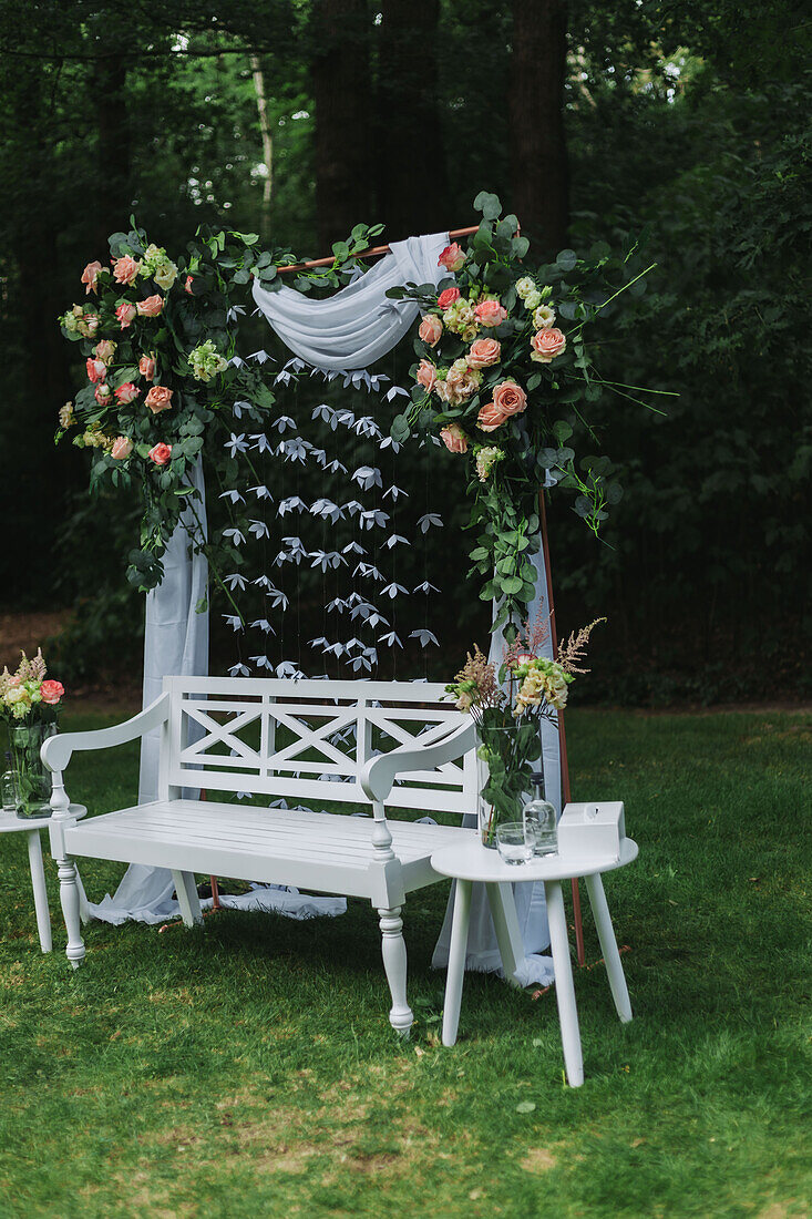 Dekorierte weiße Holzbank für Hochzeit im Garten