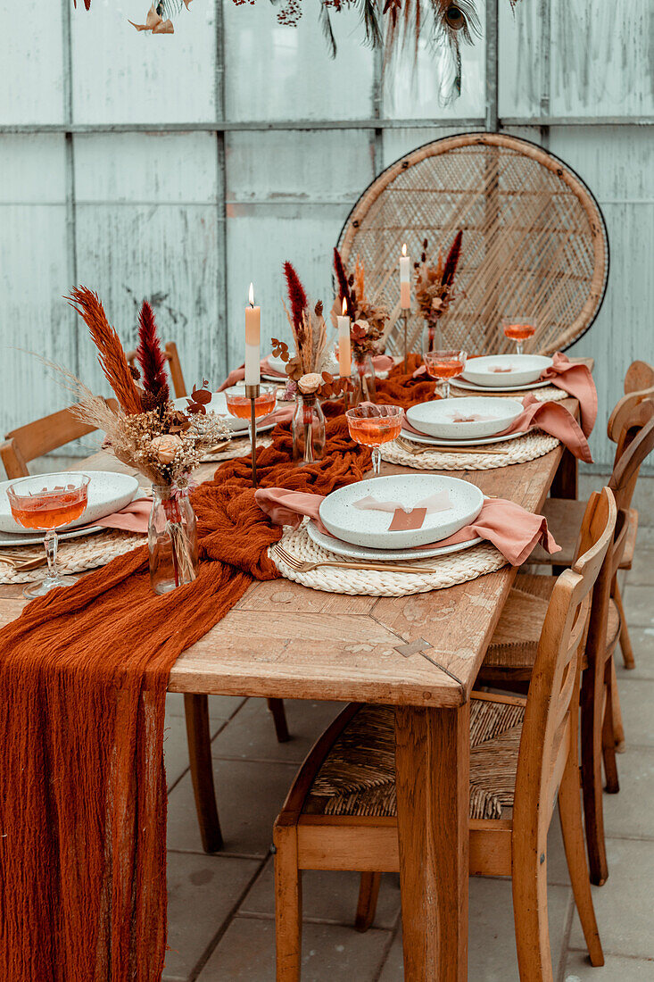 Dining table set with autumn decorations, dried flowers and candles