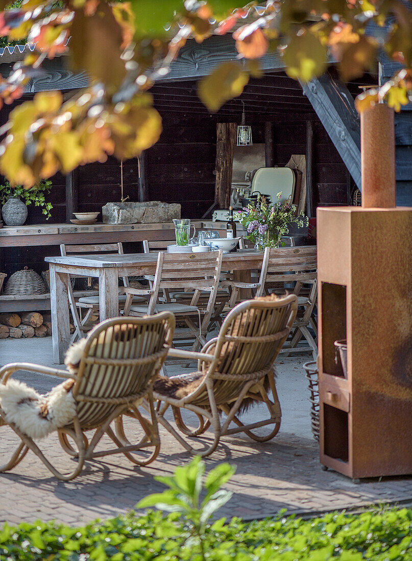 Rustic outdoor area with rattan furniture and fire pit