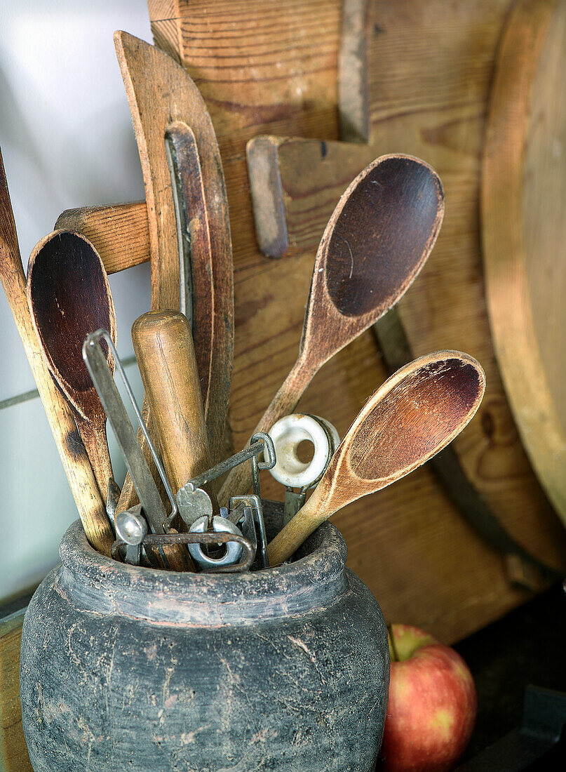 Wooden kitchen utensils in antique earthenware jug