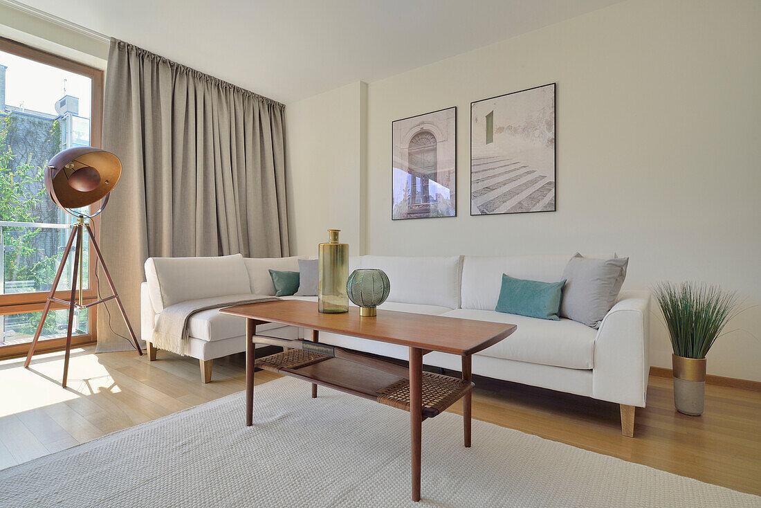 Living room with white sofa, coffee table and tripod floor lamp
