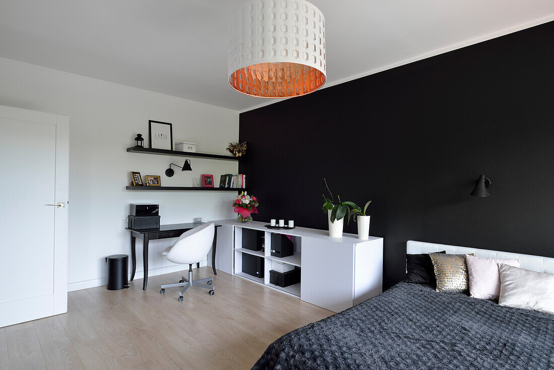 Bedroom with black accent wall, desk and white sideboard