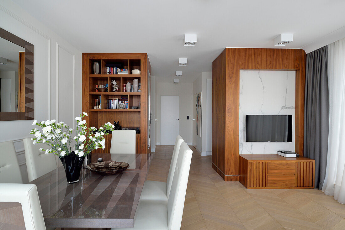 Dining area with glass dining table and modern wooden furniture