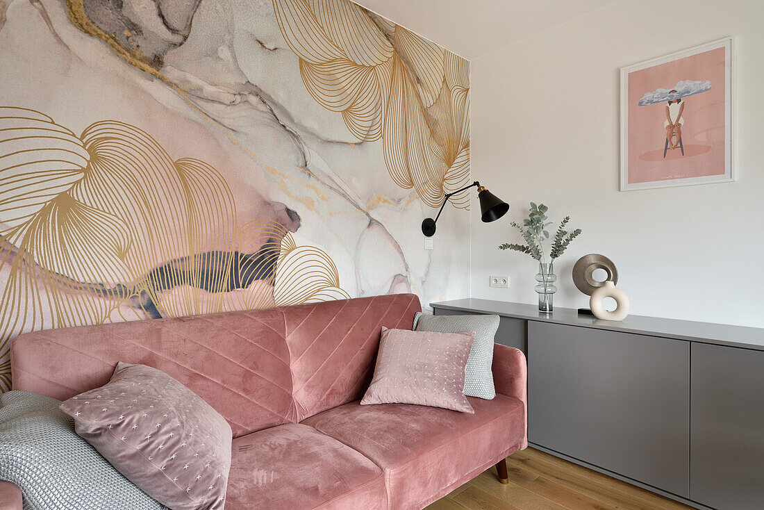 Velvet sofa in dusky pink in front of wall design with abstract pattern