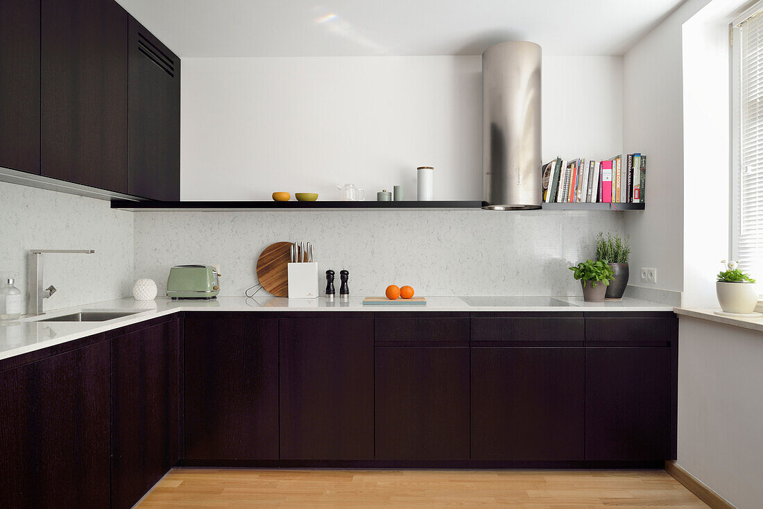 Modern kitchen with dark cabinets and extractor fan