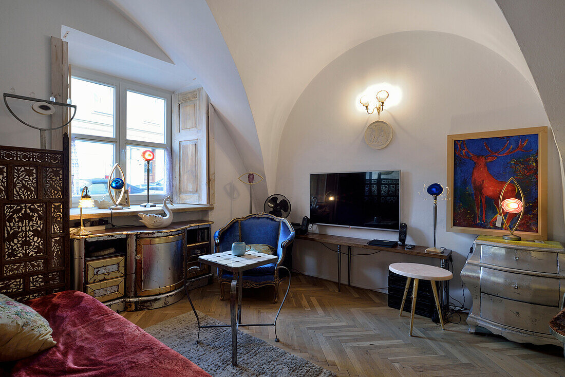 Living room with vaulted ceiling, herringbone parquet flooring and eclectic furnishings