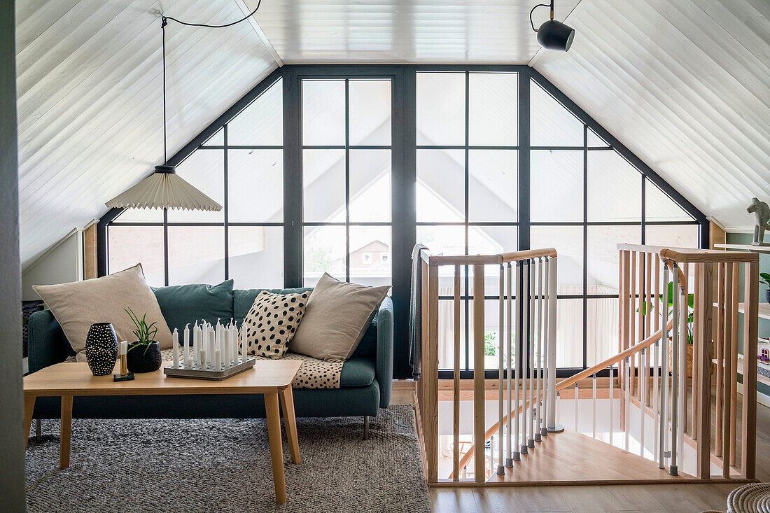 Living area in the attic with large windows and spiral staircase