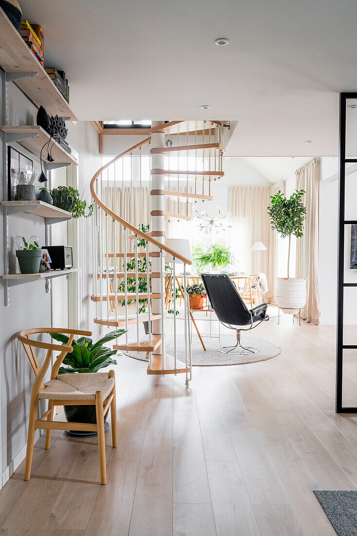 Bright living room with spiral staircase and plant arrangement