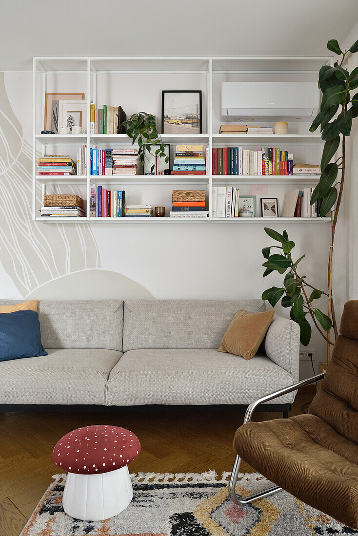 Grey sofa in front of a white bookshelf in a modern living room