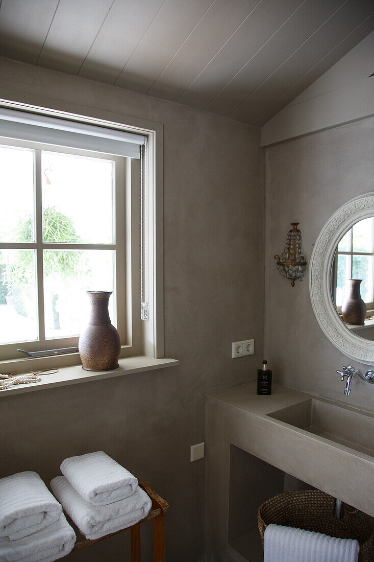 Bathroom in light brown with modern washbasin and windowsill decoration