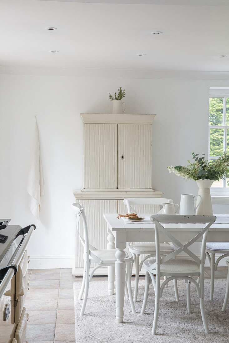 Dining area in white with country-style furniture and natural decorations