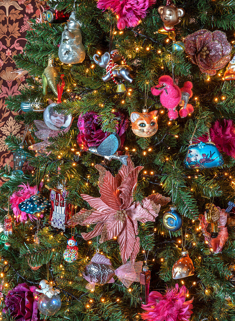 Üppig dekorierter Weihnachtsbaum mit bunten, vielfältigen Ornamenten und Lichtern