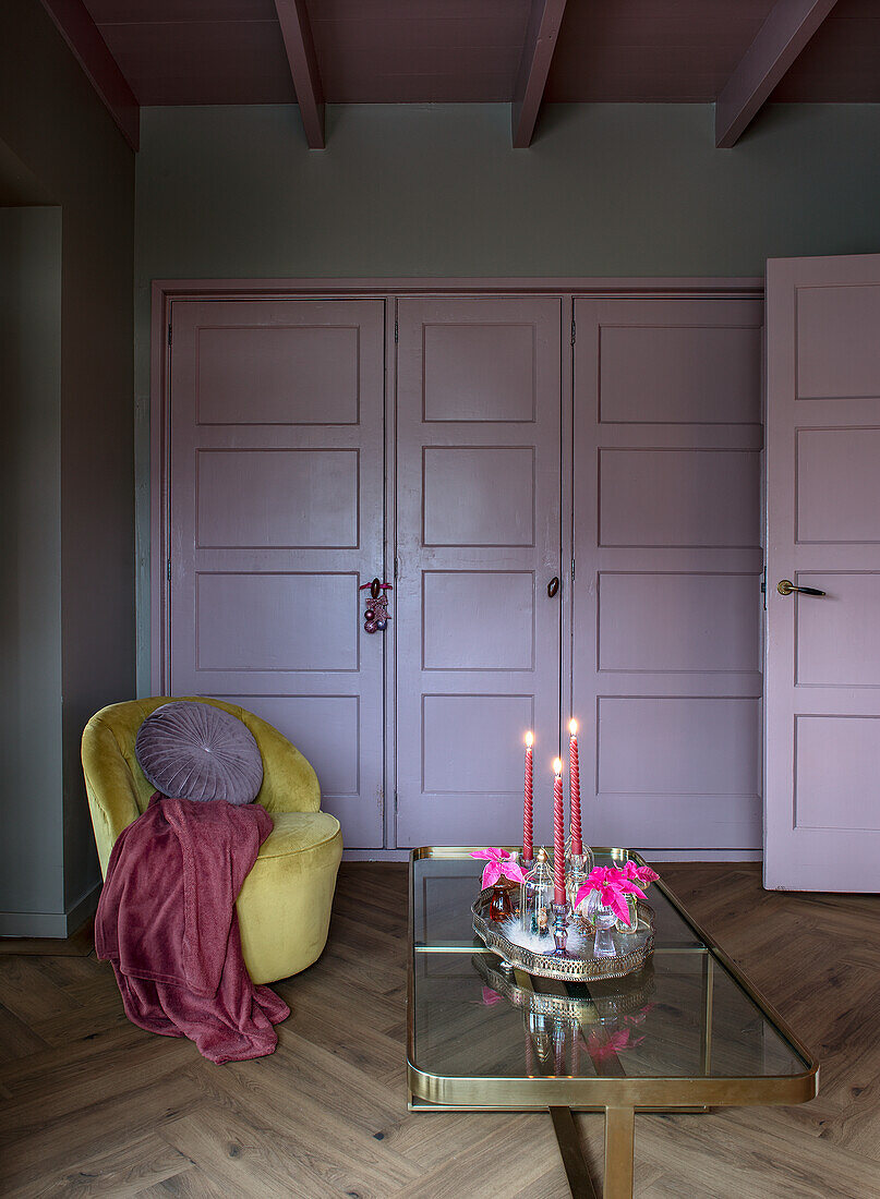 Gelber Sessel und Glas-Couchtisch in Wohnzimmer mit Schrank und Tür in Helllila