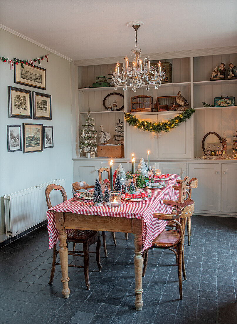 Dining room decorated for Christmas with red and white chequered tablecloth and candle lights