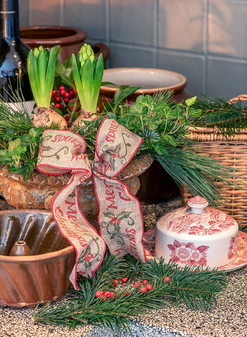 Weihnachtliche Küchen-Dekoration mit Hyazinthen, Schleife und Tannenzweigen