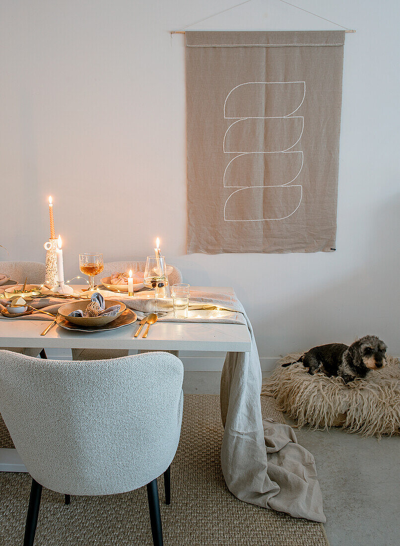 Set dining table with candles and dog in dog bed