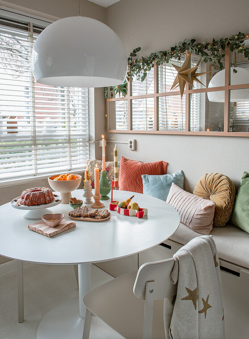 Dining area decorated for Christmas with candles, biscuits and garland