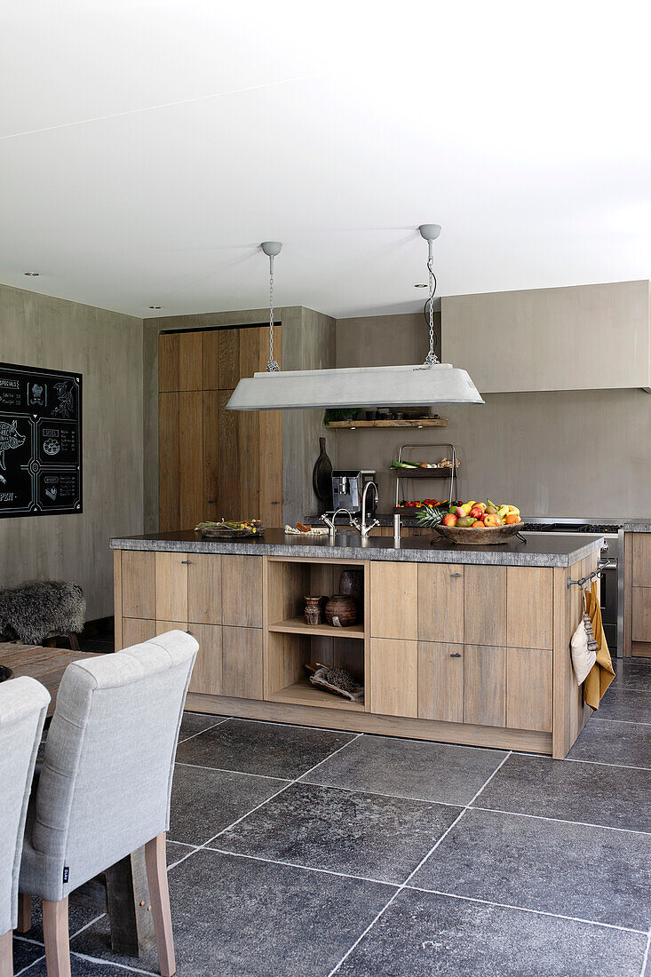 Modern kitchen with kitchen island, hanging lamp and stone tiles