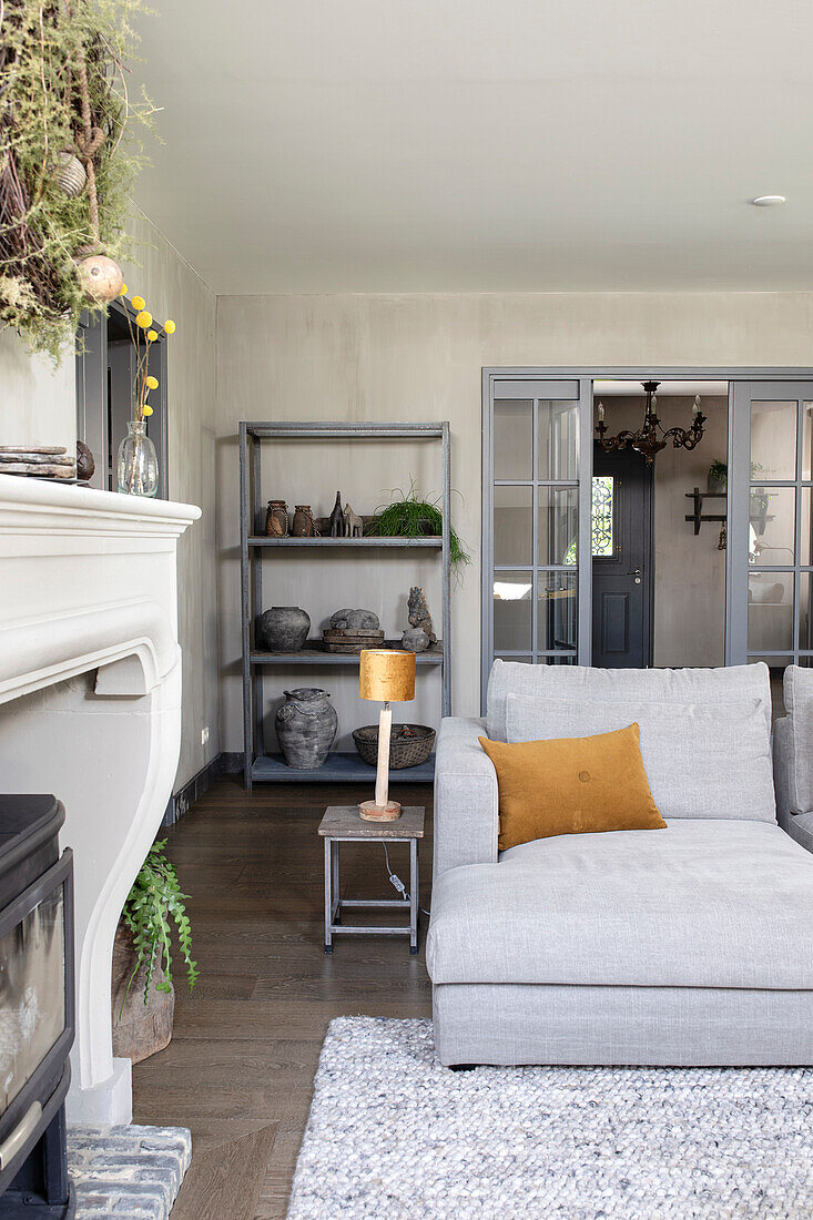 Bright living room with grey sofa and shelf