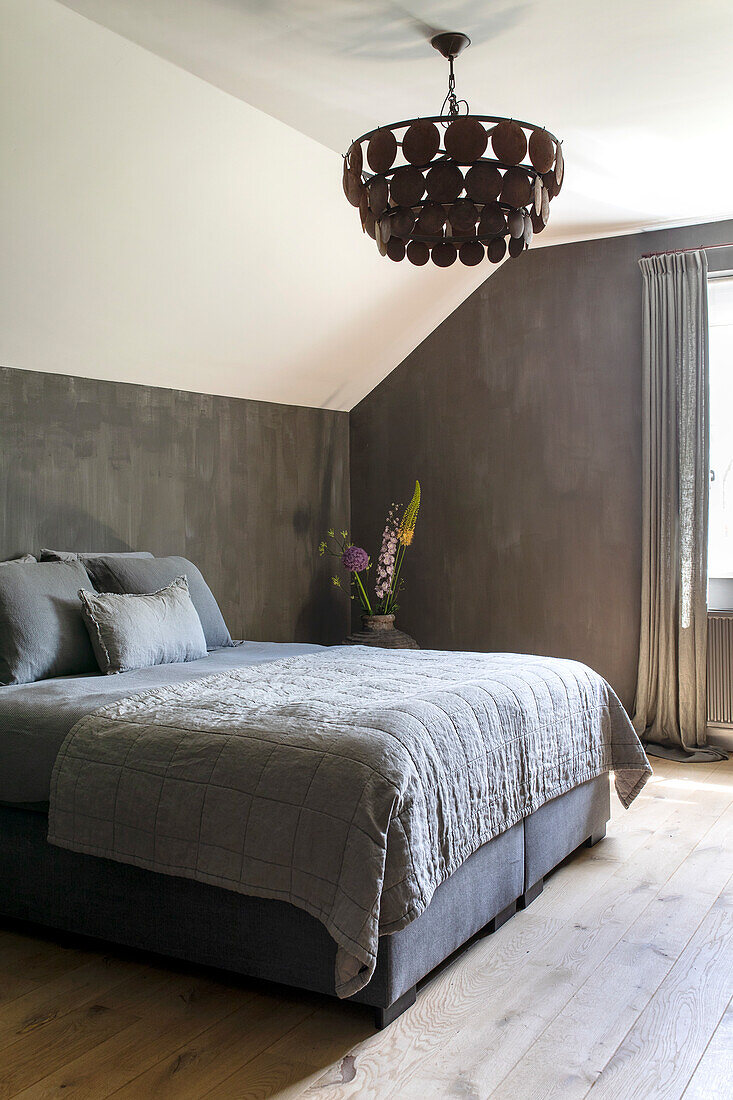 Bedroom with dark grey accent wall and large ceiling light