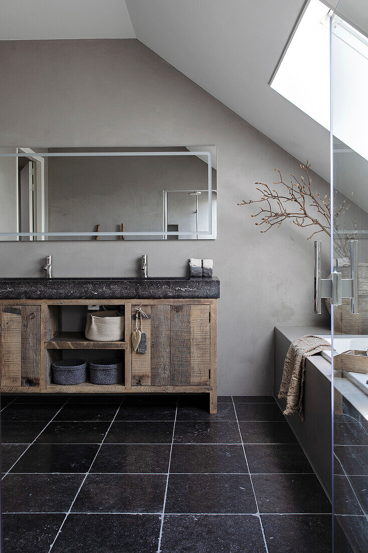 Bathroom with rustic wooden dresser and modern glass shower