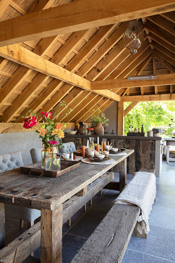 Rustic dining area with wooden table under exposed roof beams