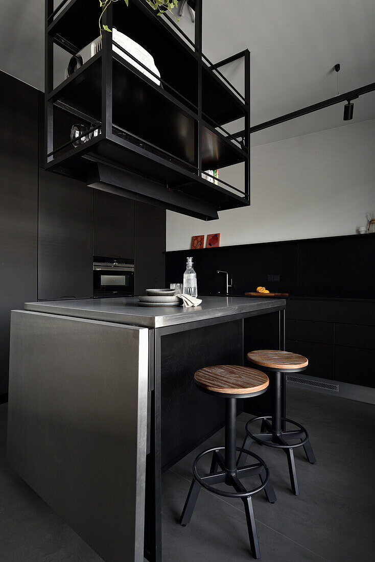 Stainless steel kitchen island with bar stools and metal shelves