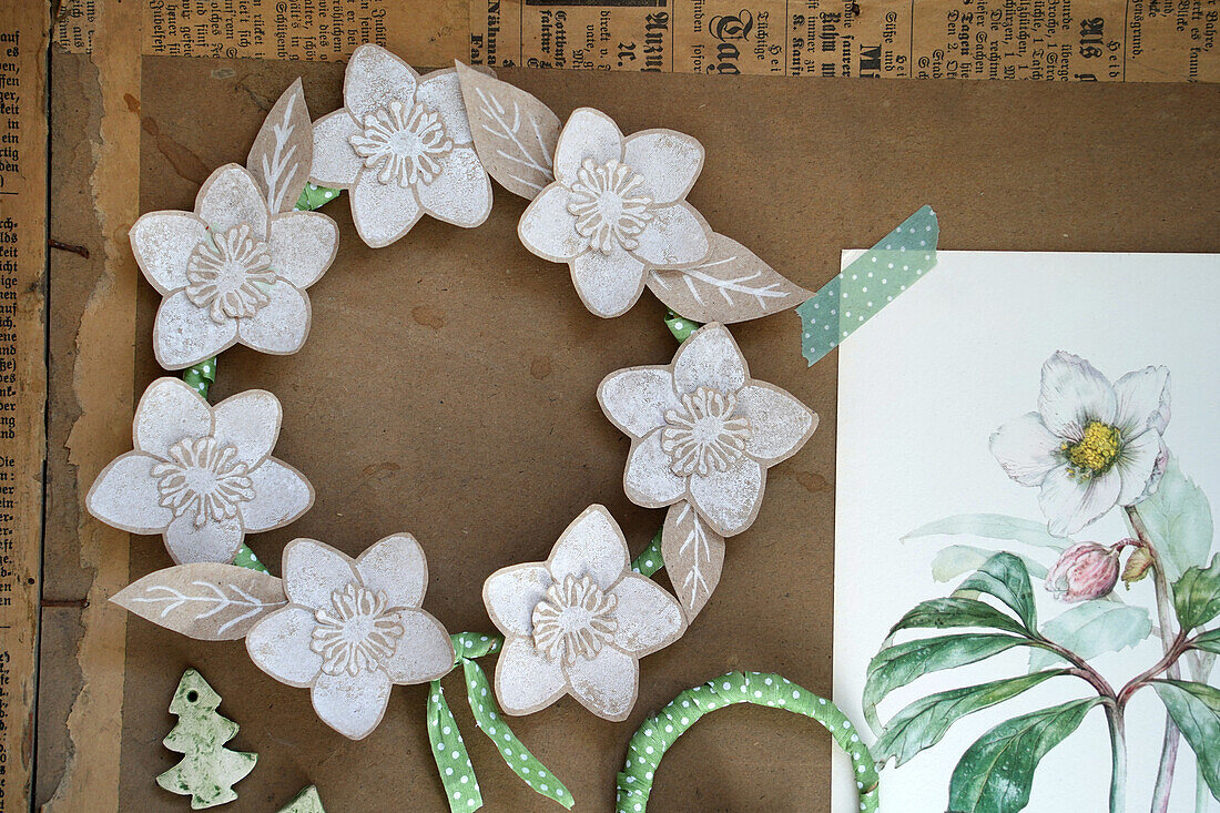 DIY paper flower wreath with green accents and watercolour drawing