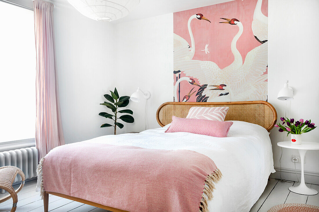 Bedroom with pink accents and wallpaper with heron print