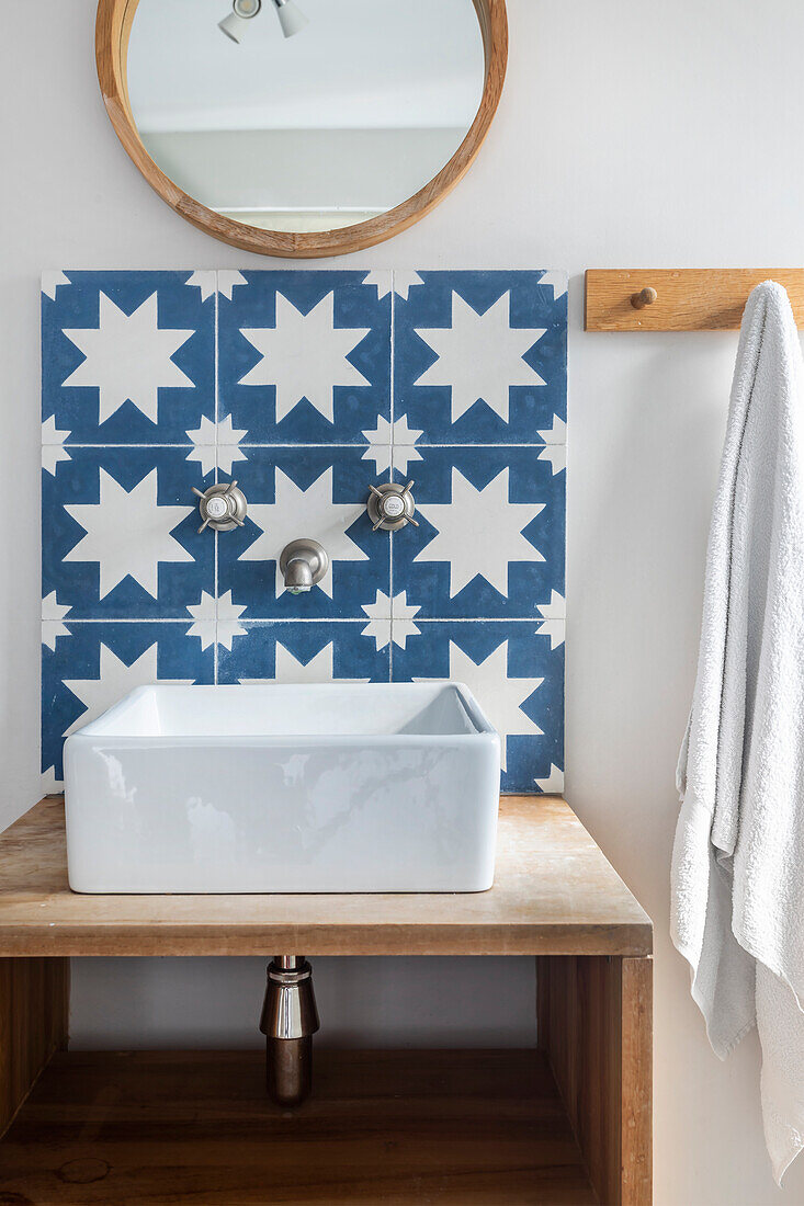 Bathroom with blue and white star tiles and round mirror