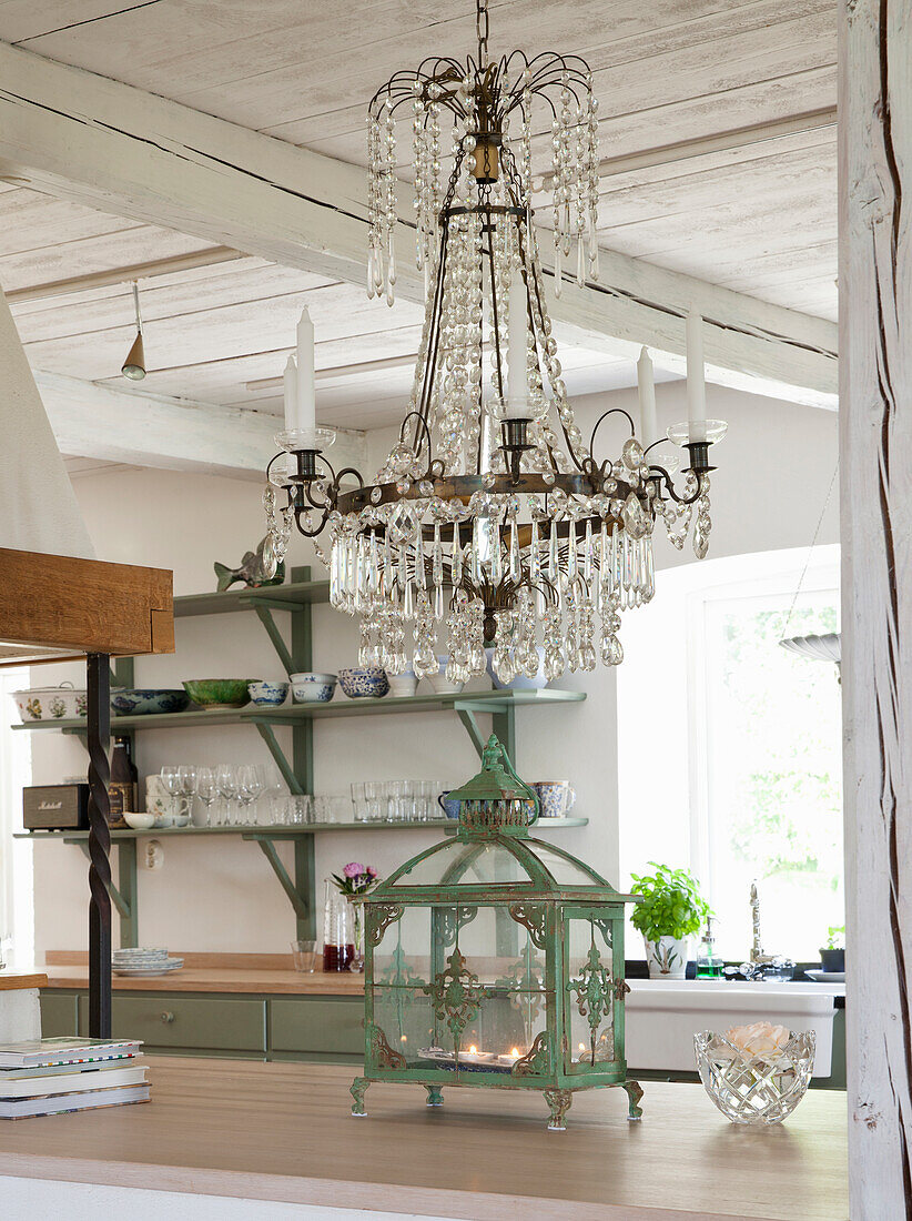 Crystal chandelier above kitchen island with antique lantern