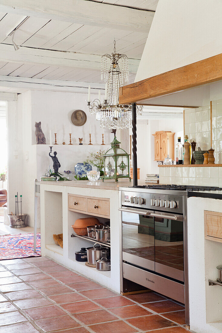 Open country kitchen with terracotta tiles and crystal chandelier