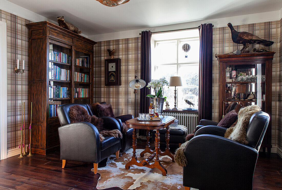 Rustic living room with leather chairs, wooden table and checkered wallpaper