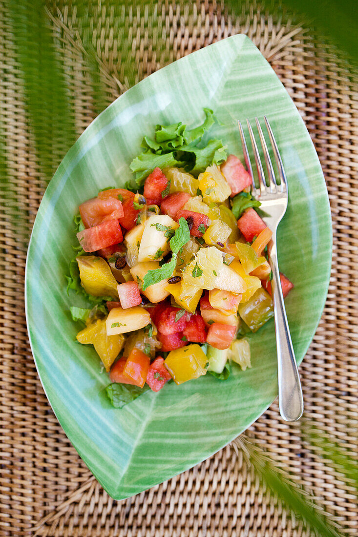 Frischer Obstsalat auf einem grünen, blattförmigen Teller