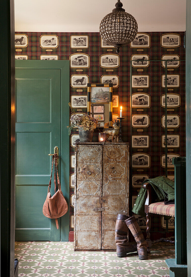 Entrance area with vintage wallpaper, metal chest of drawers and green wooden door